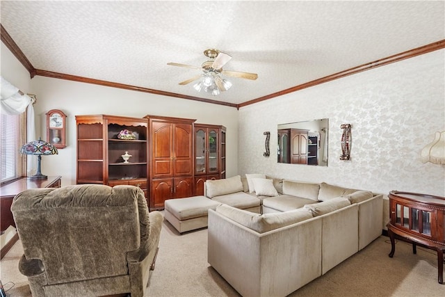 living area with light colored carpet, a ceiling fan, a textured ceiling, and ornamental molding