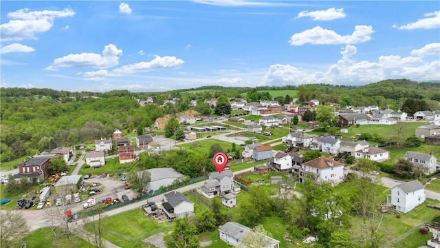 aerial overview of property's location featuring nearby suburban area and a heavily wooded area