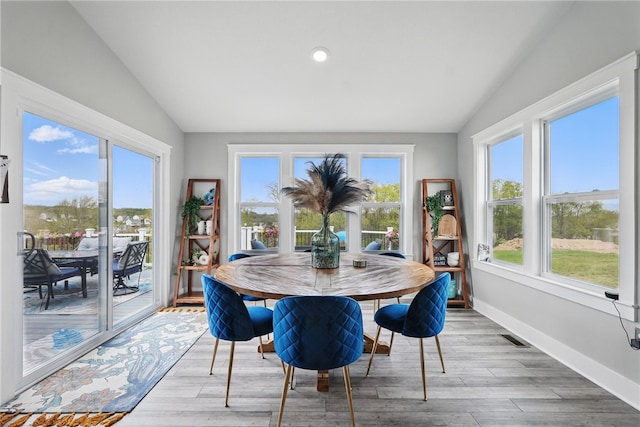 dining room with vaulted ceiling, healthy amount of natural light, wood finished floors, and recessed lighting