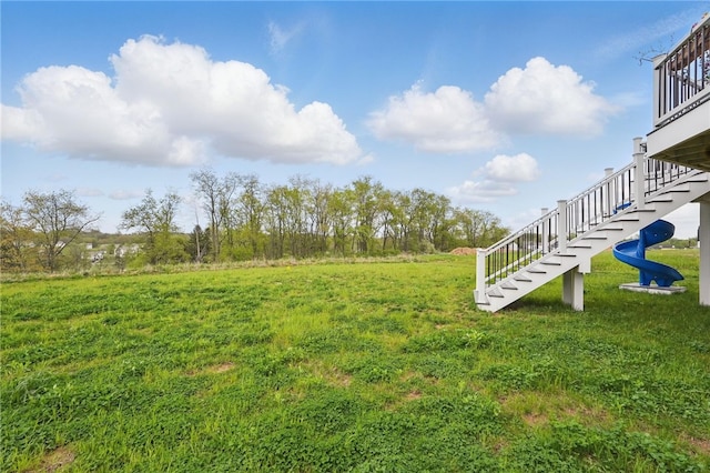 view of green lawn featuring stairway