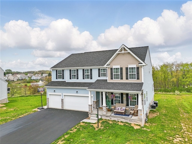 traditional-style house featuring a shingled roof, asphalt driveway, an attached garage, cooling unit, and a porch