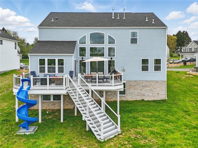 back of house with a wooden deck, a yard, stairs, and brick siding
