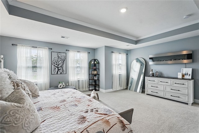 bedroom featuring light carpet, baseboards, a tray ceiling, recessed lighting, and arched walkways