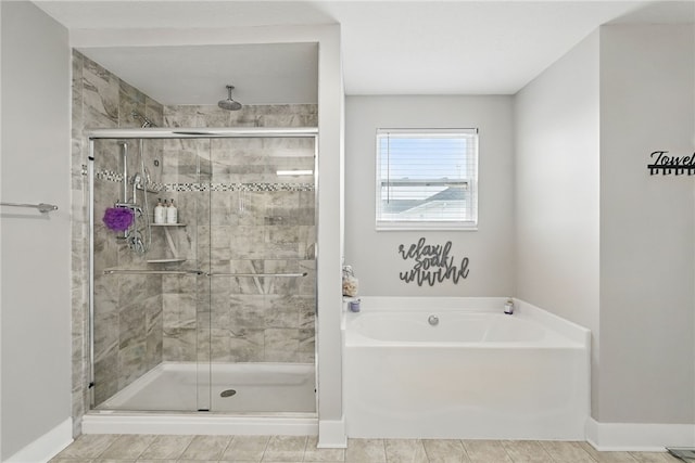 full bath with a garden tub, a shower stall, and baseboards
