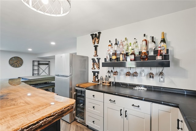 indoor wet bar featuring wine cooler, recessed lighting, and freestanding refrigerator