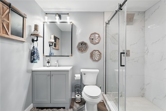 bathroom with a marble finish shower, toilet, wood finished floors, and vanity