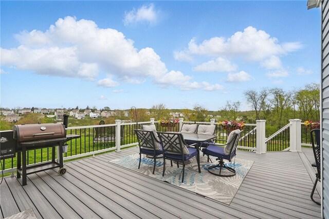 wooden terrace with outdoor dining area and grilling area