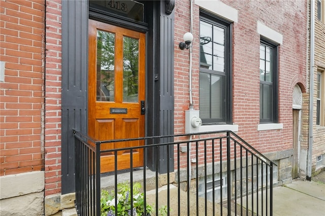 doorway to property with brick siding