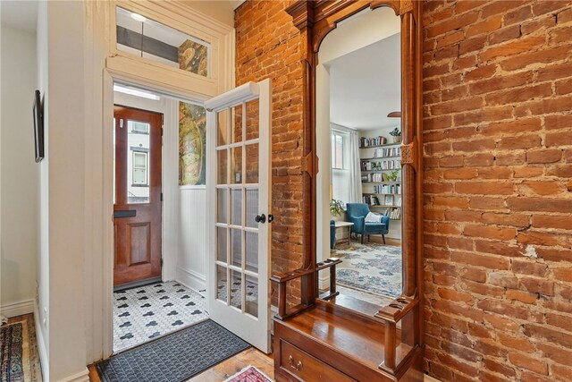 doorway with brick wall and baseboards
