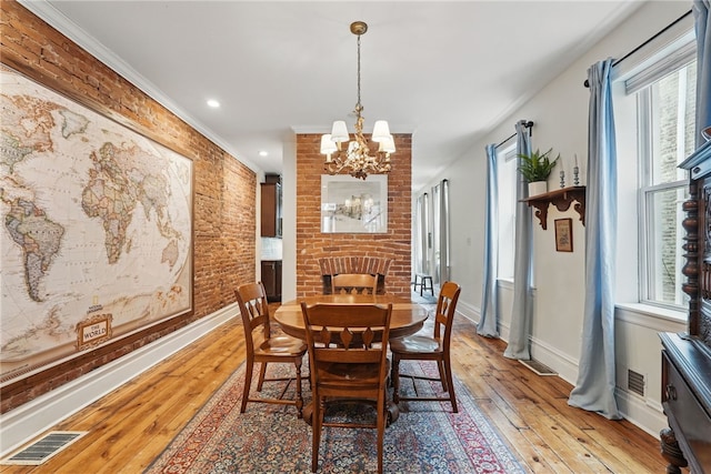 dining space with a chandelier, healthy amount of natural light, light wood-style floors, baseboards, and crown molding