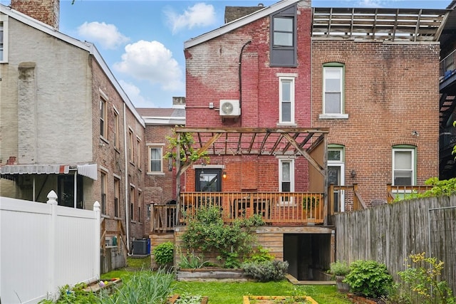 rear view of house with brick siding, a deck, central air condition unit, fence, and ac unit