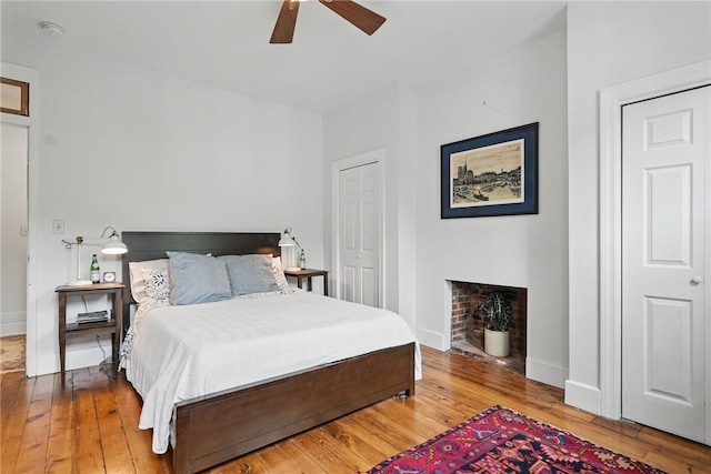 bedroom featuring light wood-type flooring, baseboards, and a fireplace