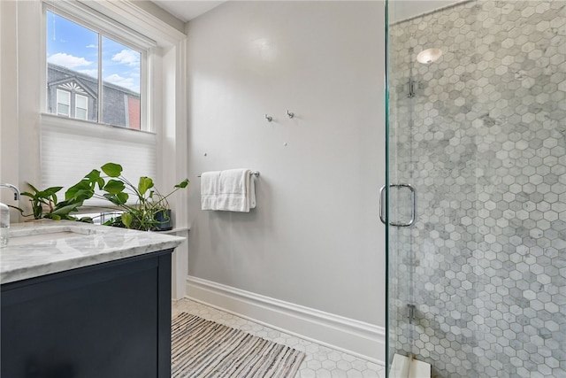 bathroom with a stall shower, vanity, tile patterned floors, and baseboards