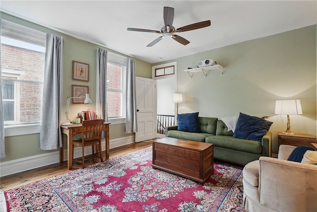 living room featuring ceiling fan, wood finished floors, and baseboards