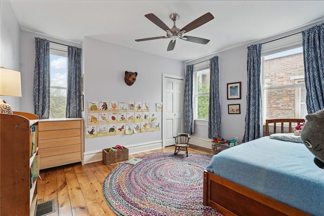 bedroom featuring wood-type flooring, baseboards, and a ceiling fan