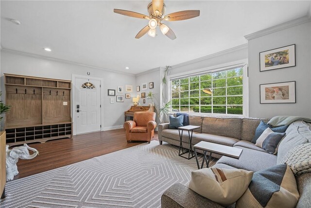 living area featuring wood finished floors, crown molding, a ceiling fan, recessed lighting, and baseboards