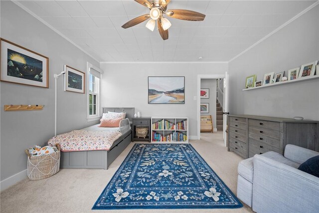 bedroom featuring carpet flooring, baseboards, ornamental molding, and ceiling fan