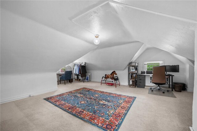 home office with carpet flooring and vaulted ceiling