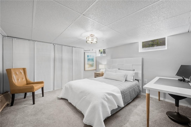 carpeted bedroom with a paneled ceiling