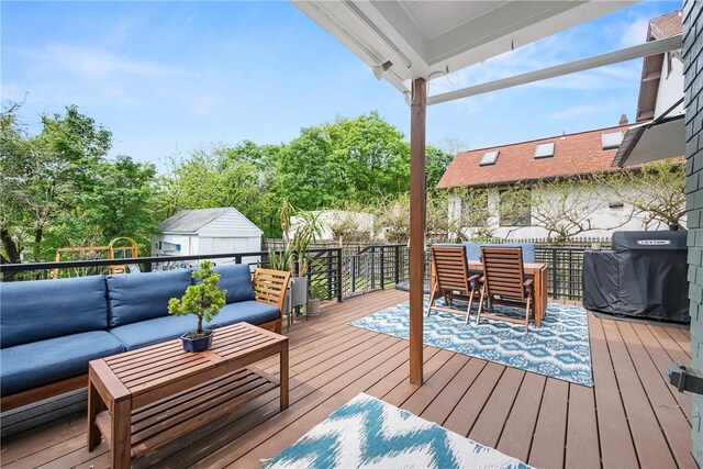 wooden terrace with an outdoor living space and grilling area