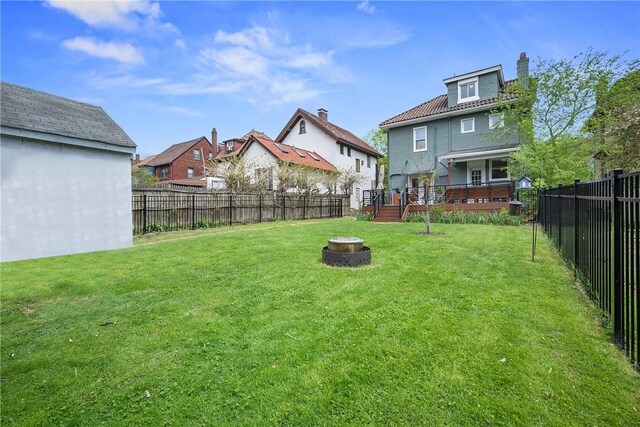 view of yard featuring a fire pit, a residential view, and a wooden deck