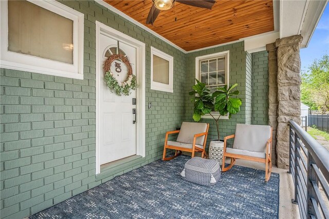 property entrance with ceiling fan and brick siding