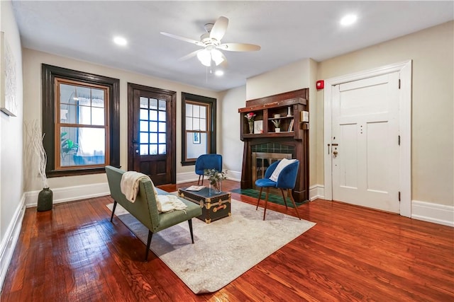 living area with baseboards, wood finished floors, ceiling fan, and recessed lighting