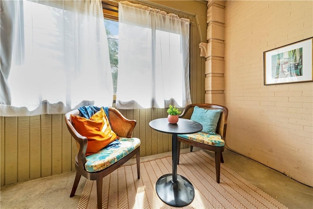 sitting room featuring brick wall