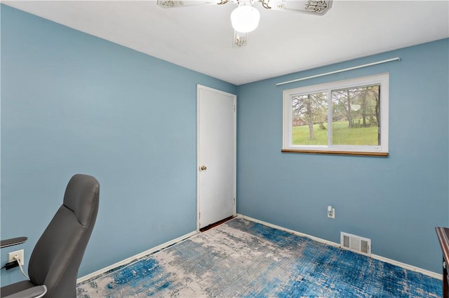 unfurnished office featuring ceiling fan and baseboards