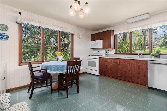 108 Crestview Dr, Evans City Boro, PA 16033 - kitchen featuring white appliances, wallpapered walls, a chandelier, light countertops, and a sink