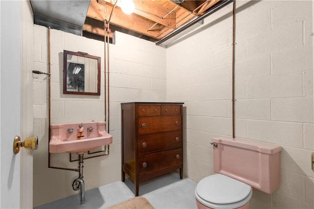 108 Crestview Dr, Evans City Boro, PA 16033 - bathroom with concrete block wall, toilet, a sink, and concrete flooring