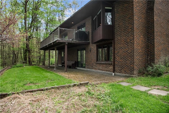 108 Crestview Dr, Evans City Boro, PA 16033 - back of property featuring brick siding, a lawn, a patio area, and central AC
