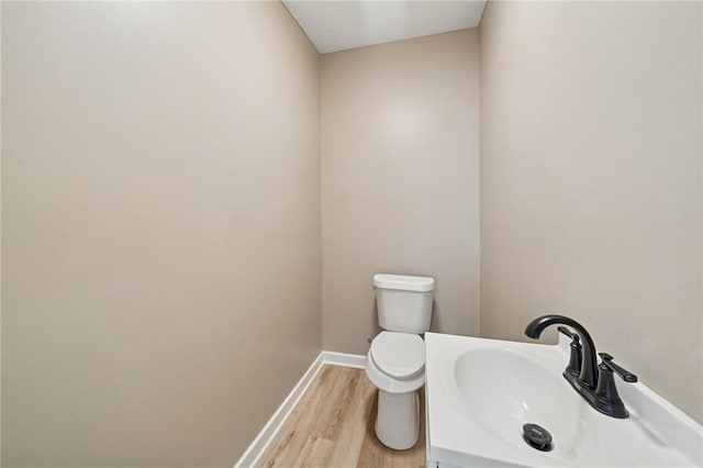 232 57th St, Lawrenceville, PA 15201 - half bathroom featuring a sink, baseboards, wood finished floors, and toilet