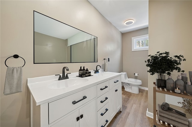 232 57th St, Lawrenceville, PA 15201 - bathroom with wood finished floors, double vanity, toilet, and baseboards