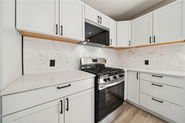 232 57th St, Lawrenceville, PA 15201 - kitchen with stainless steel range with gas stovetop, light stone counters, white cabinets, and light wood-type flooring