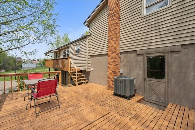 deck featuring cooling unit, stairway, and outdoor dining area