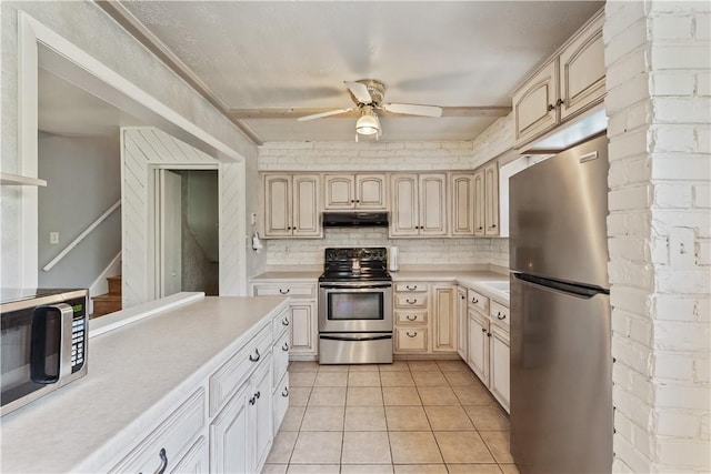 kitchen featuring appliances with stainless steel finishes, light countertops, ceiling fan, and under cabinet range hood