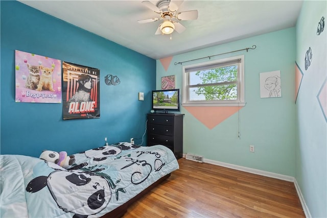 bedroom featuring wood finished floors, baseboards, and ceiling fan