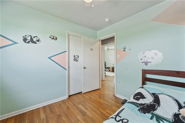 bedroom featuring light wood-style flooring, baseboards, and ceiling fan