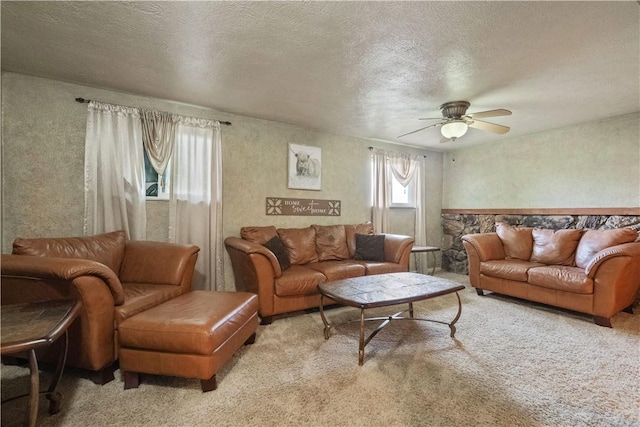 carpeted living area featuring a ceiling fan and a textured ceiling