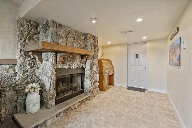 unfurnished living room with a stone fireplace, recessed lighting, and baseboards