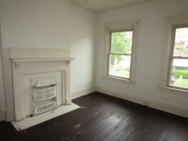 unfurnished living room with dark wood-style floors and plenty of natural light