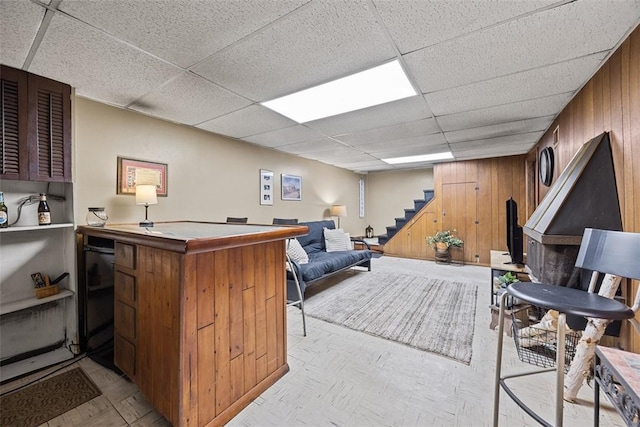 interior space with stairs, wood walls, and a paneled ceiling