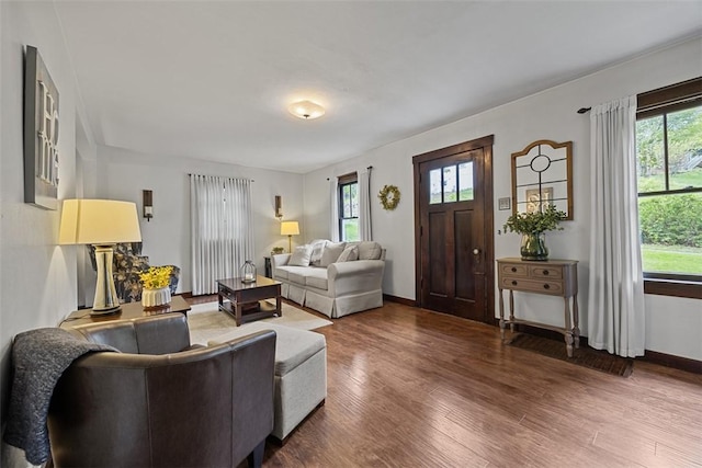 living area featuring healthy amount of natural light, wood finished floors, and baseboards