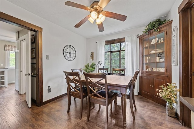 dining room with dark wood-type flooring, healthy amount of natural light, and a ceiling fan