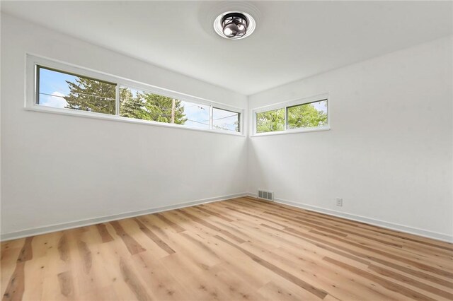 spare room featuring wood finished floors and baseboards