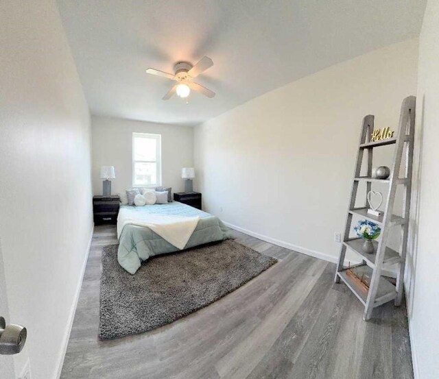 bedroom featuring wood finished floors, baseboards, and ceiling fan