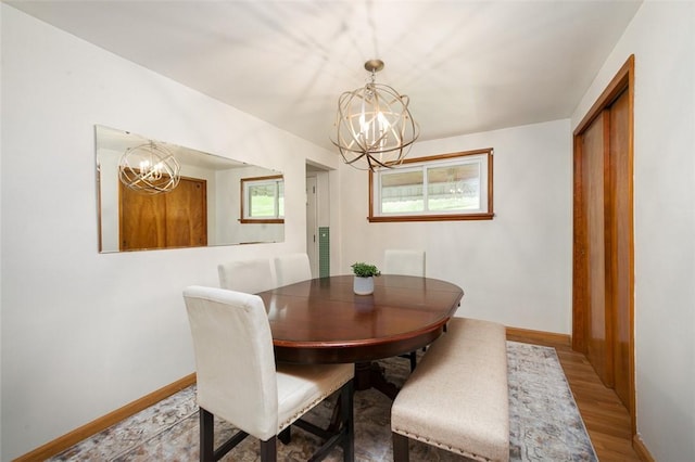 1104 Bennett Ave, Jeannette, PA 15644 - dining area featuring a chandelier, wood finished floors, and baseboards