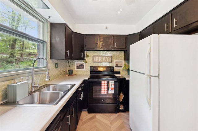 kitchen with freestanding refrigerator, a sink, black electric range, light countertops, and dark brown cabinets