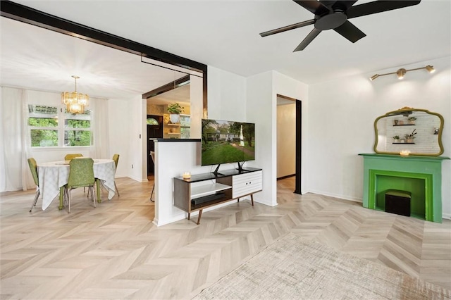 living room with a chandelier, ceiling fan, and baseboards